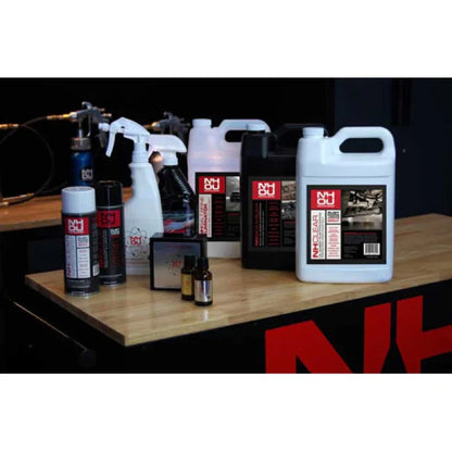 Collection of cleaning products on a wooden surface with a black background